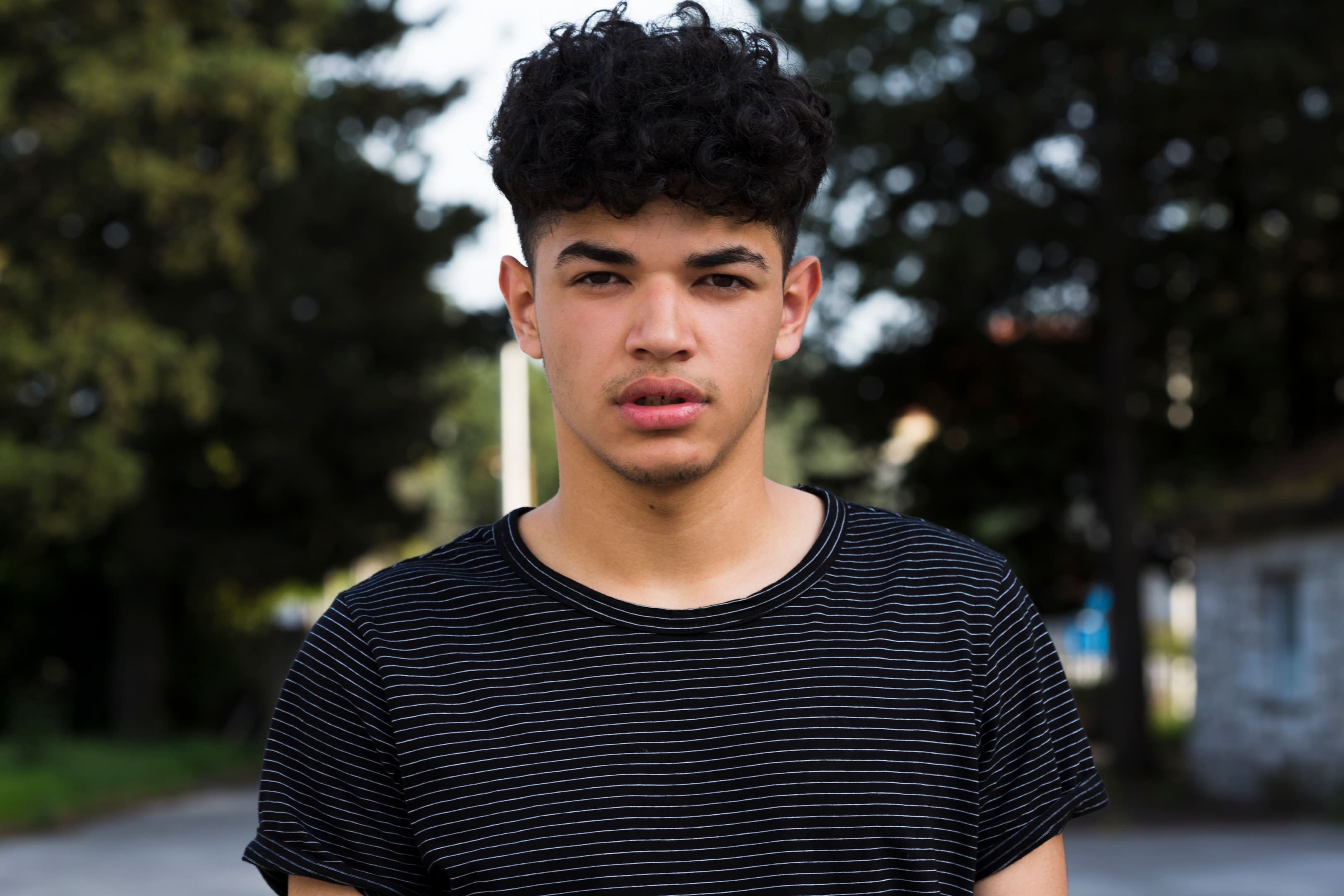 Ethnic young man looking at camera outdoors