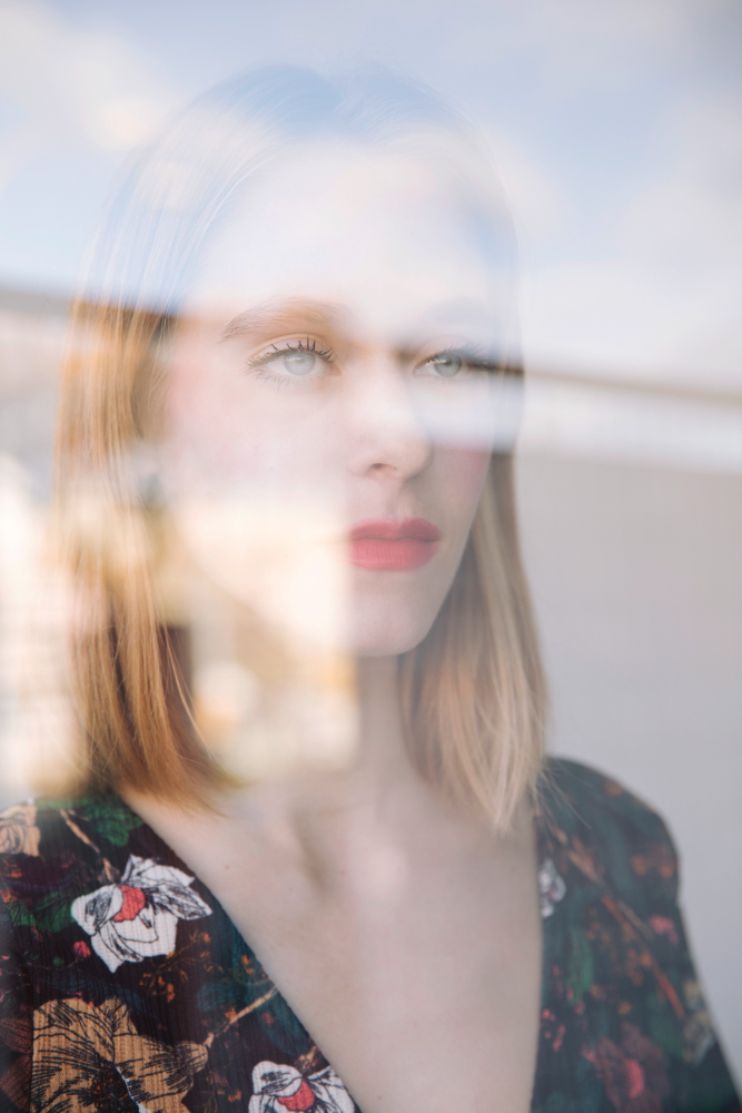 Sensual serious woman behind window