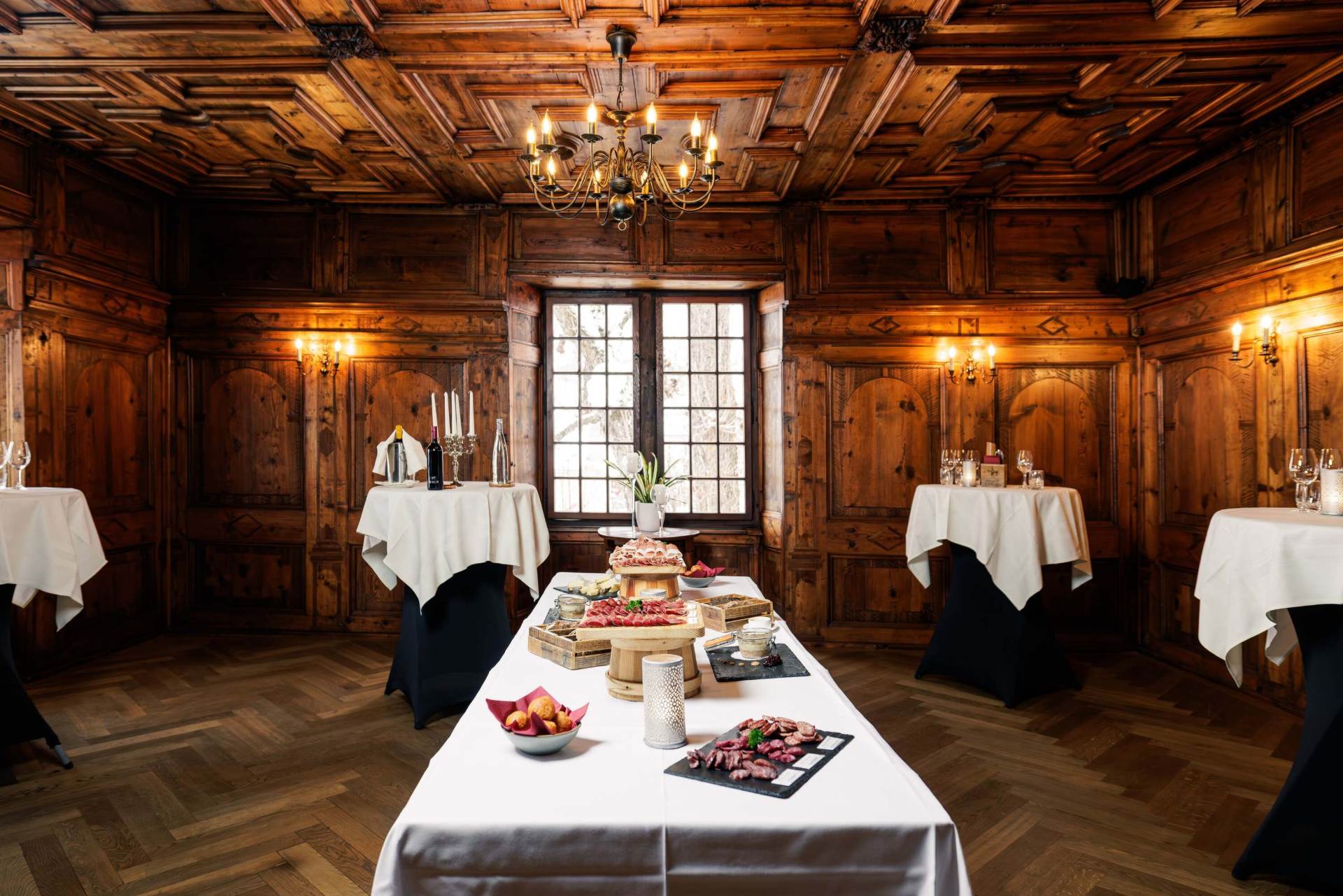 Salle boisée du Château de Villa dressée pour un banquet, sous un lustre