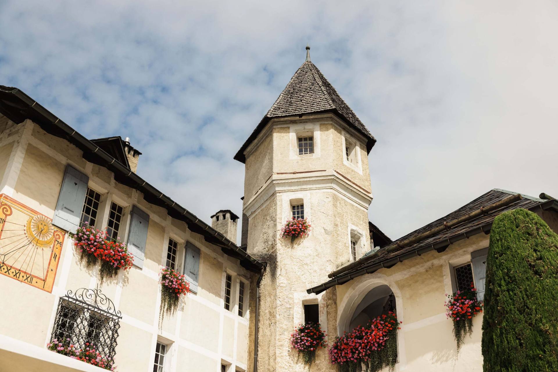 Cour du Château de Villa à Sierre, avec sa tour et ses fenêtres fleuries