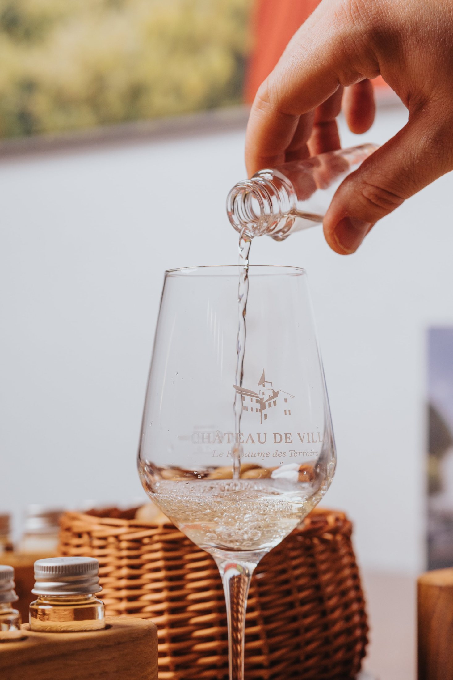 Vin blanc versé dans un verre gravé du Château de Villa