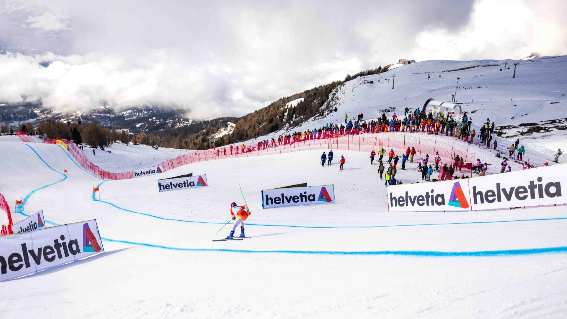 Athlète en pleine descente sur la piste de Coupe du monde, devant le public
