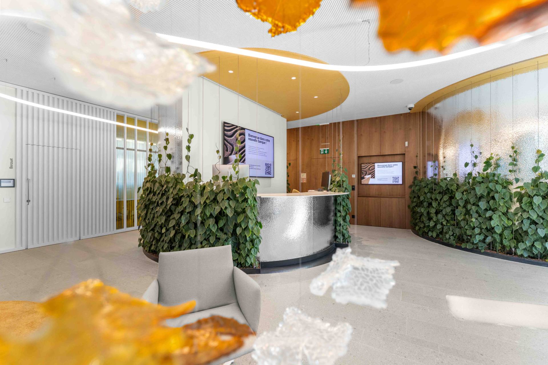Hall d'accueil de la nouvelle Banque Raiffeisen de Sierre & Région, avec plantes et comptoir