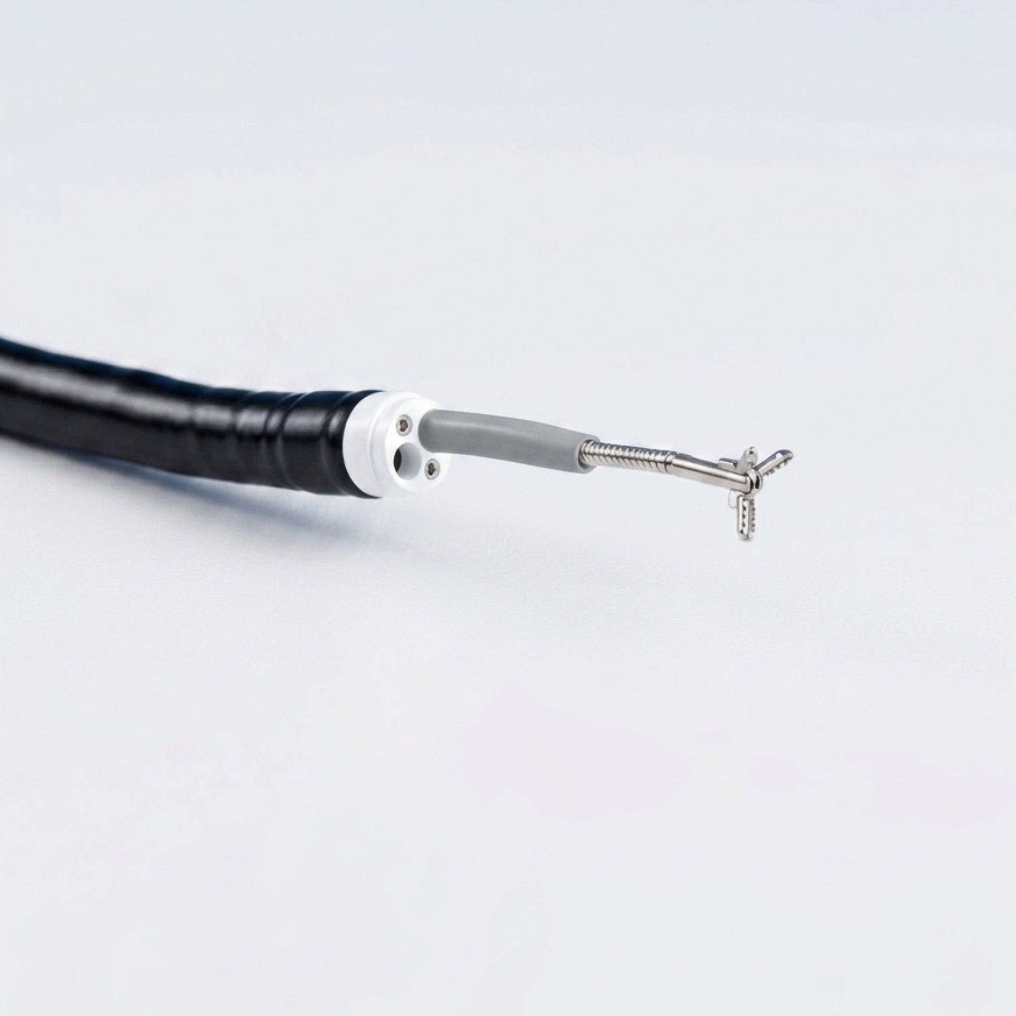 Flexible black medical endoscope with a small, three-pronged metal tool at the tip on a white background.