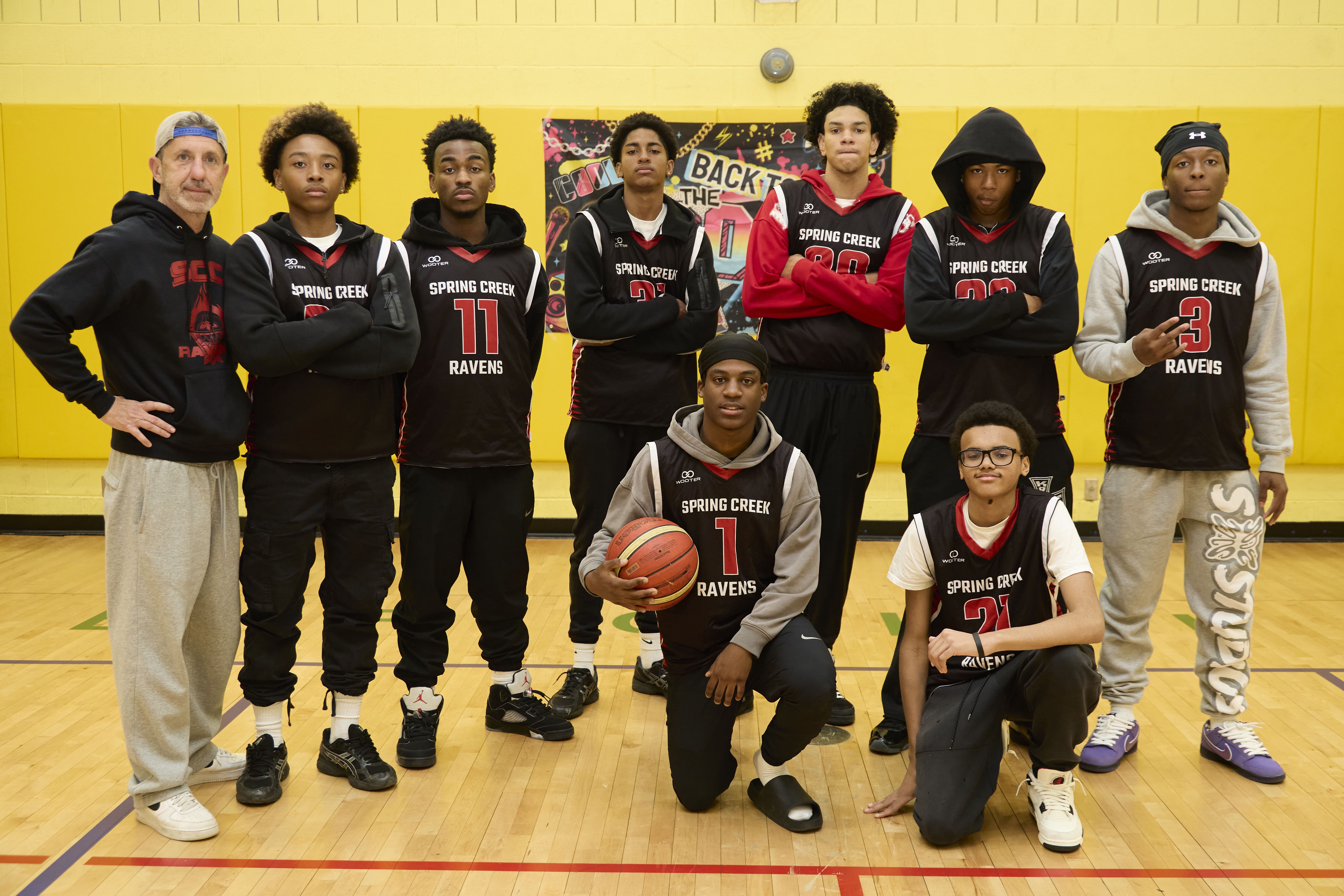 Spring Creek Ravens basketball team and coach posing in gymnasium
