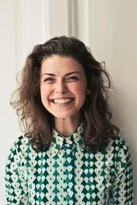 Photo of a candidate. Young woman smiling, wearing a green shirt.