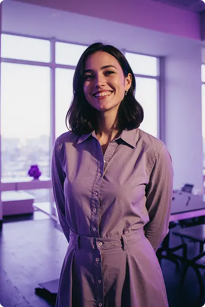 Photo of a candidate. Young white woman with dark hair, smiling and wearing beige dress.