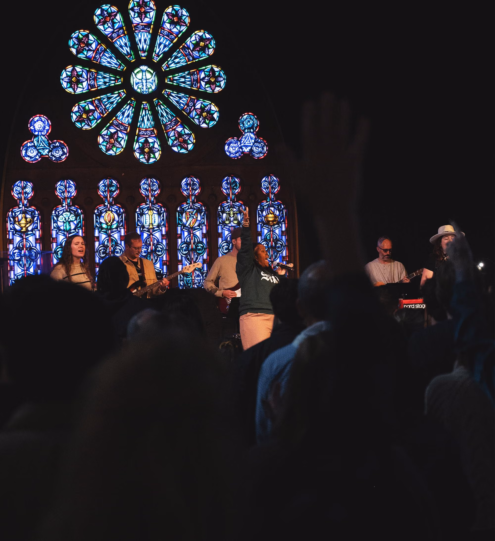 Worship band leading Sunday service at Ambassador Church Milwaukee with stained glass windows in the background