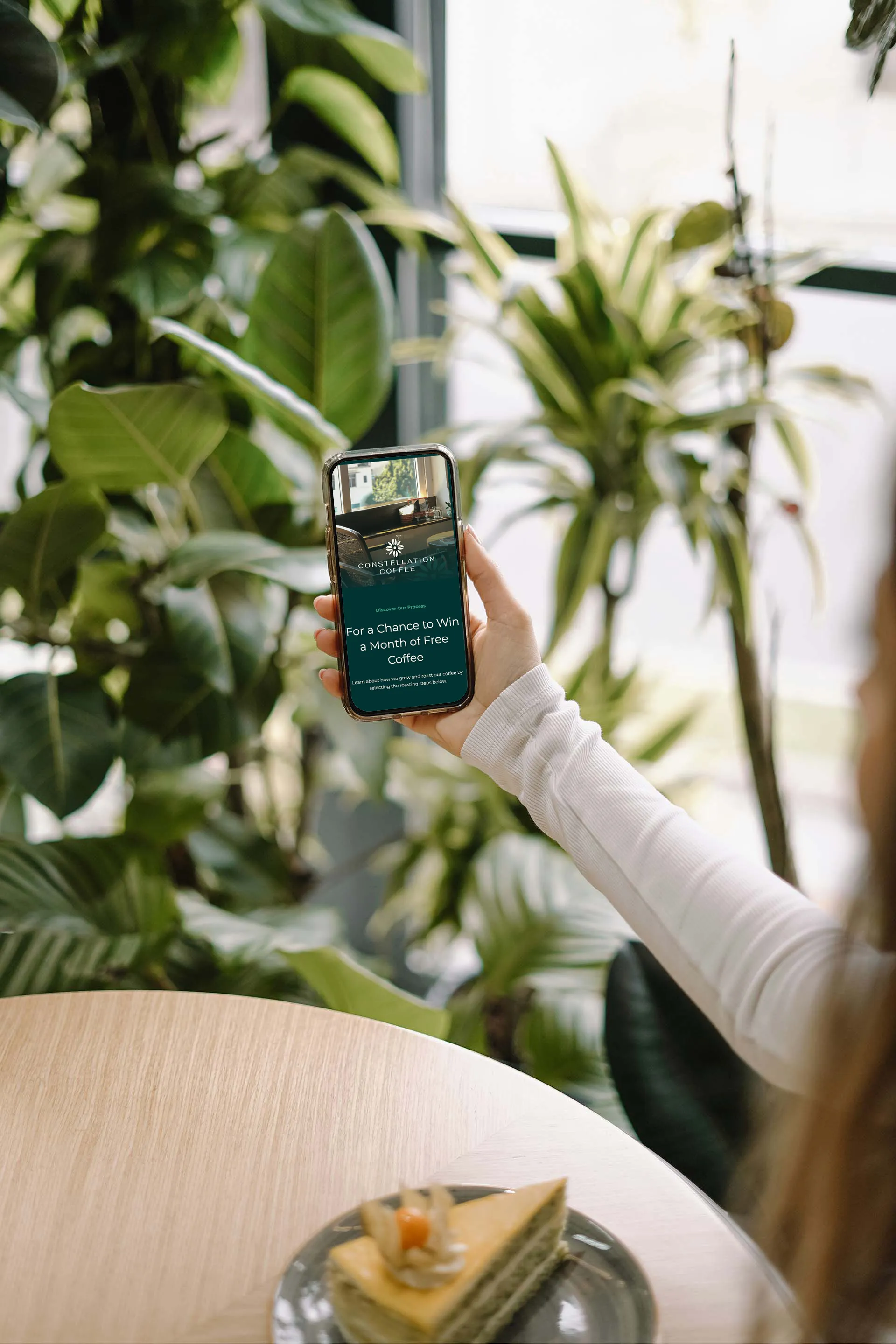 Woman holding phone in coffee shop