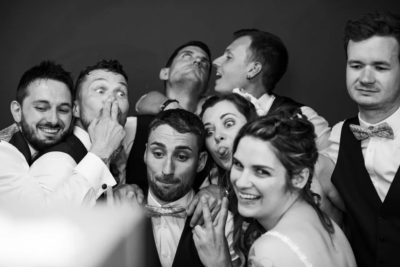 Photobooth mariage groupe invités poses drôles noir blanc