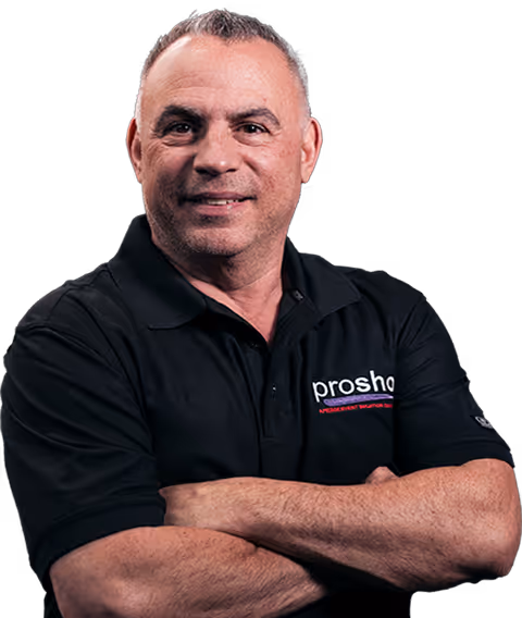 Middle-aged man with short hair wearing a black polo shirt with folded arms and a slight smile.