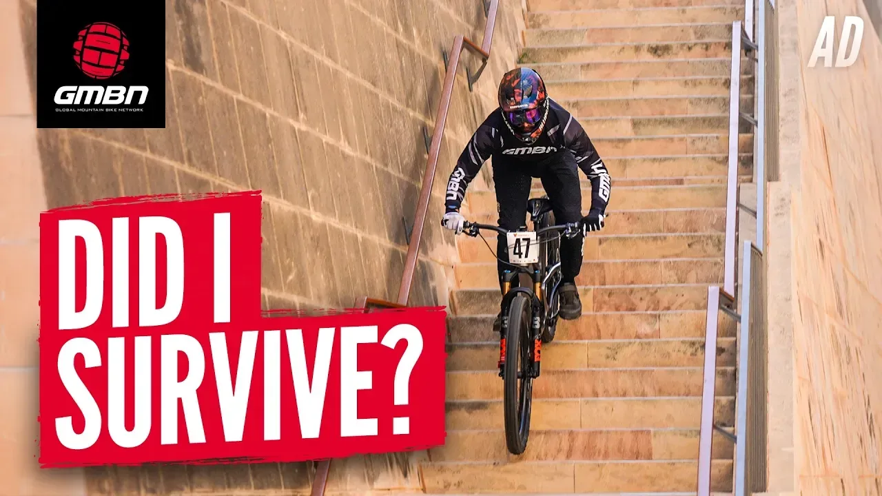 A helmeted mountain biker descending a steep staircase