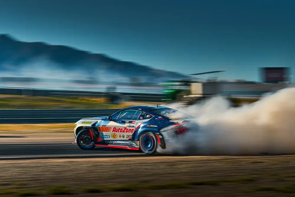 A Formula DRIFT car sliding through a cloud of tyre smoke