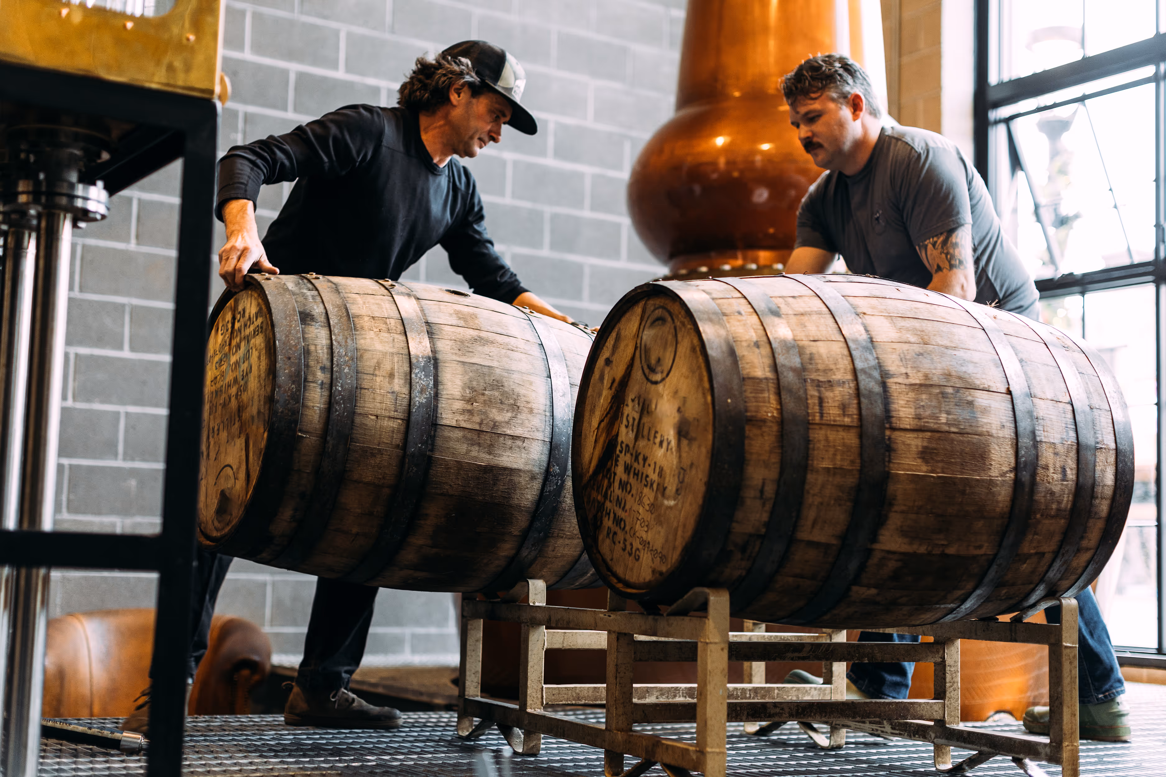 men lifting barrels onto racks