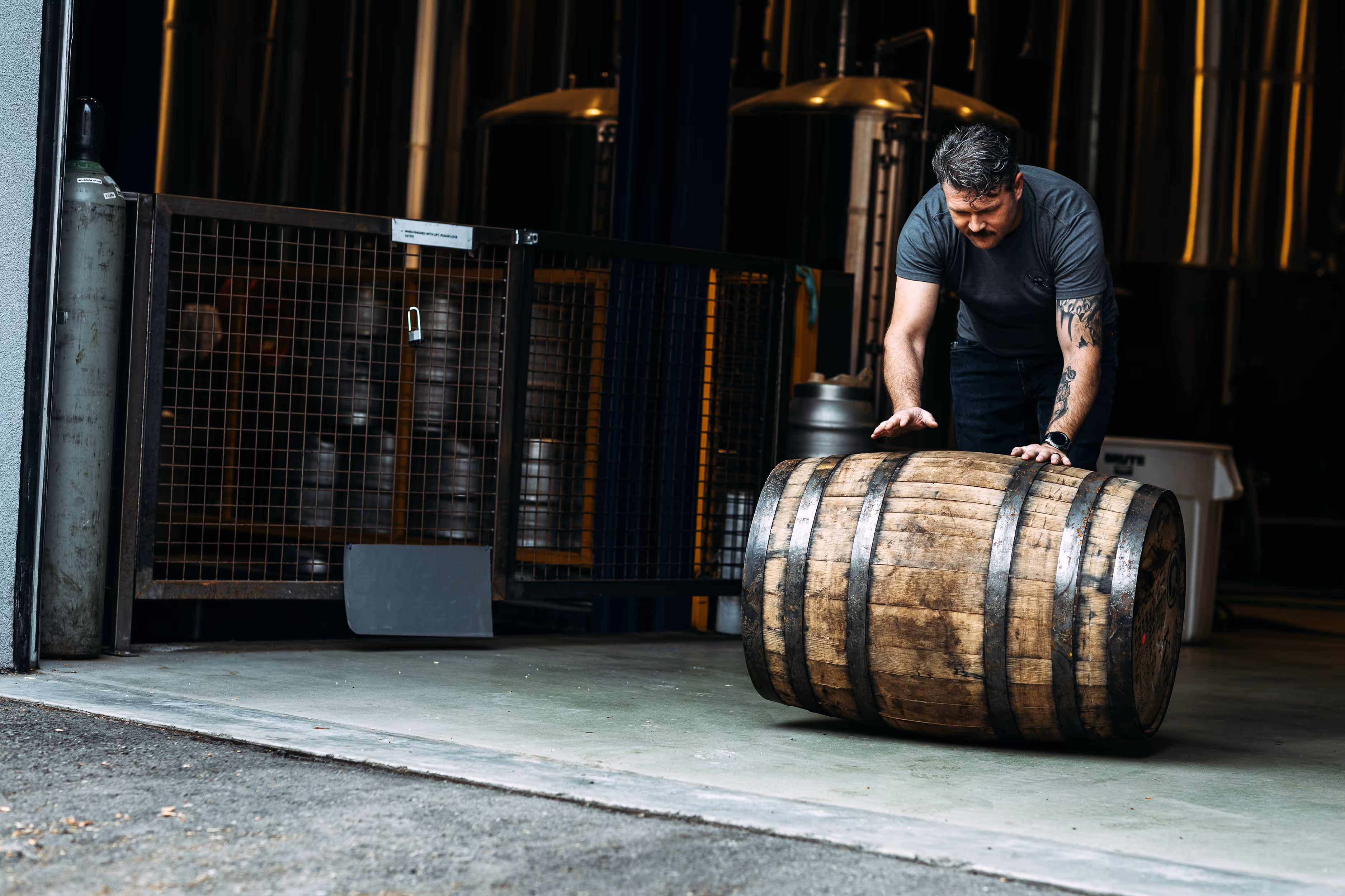 man rolling whiskey barrel