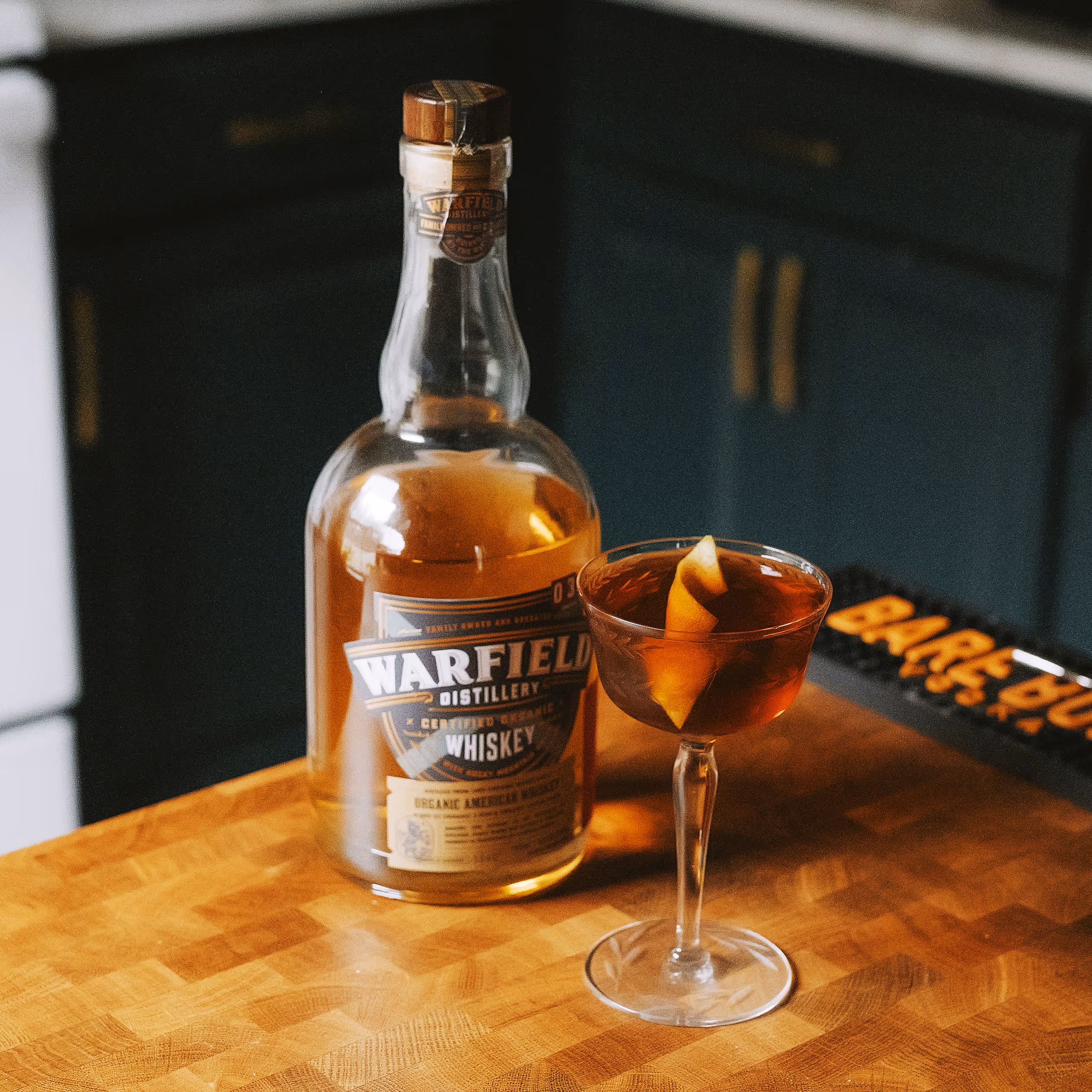 Whiskey bottle behind cocktail