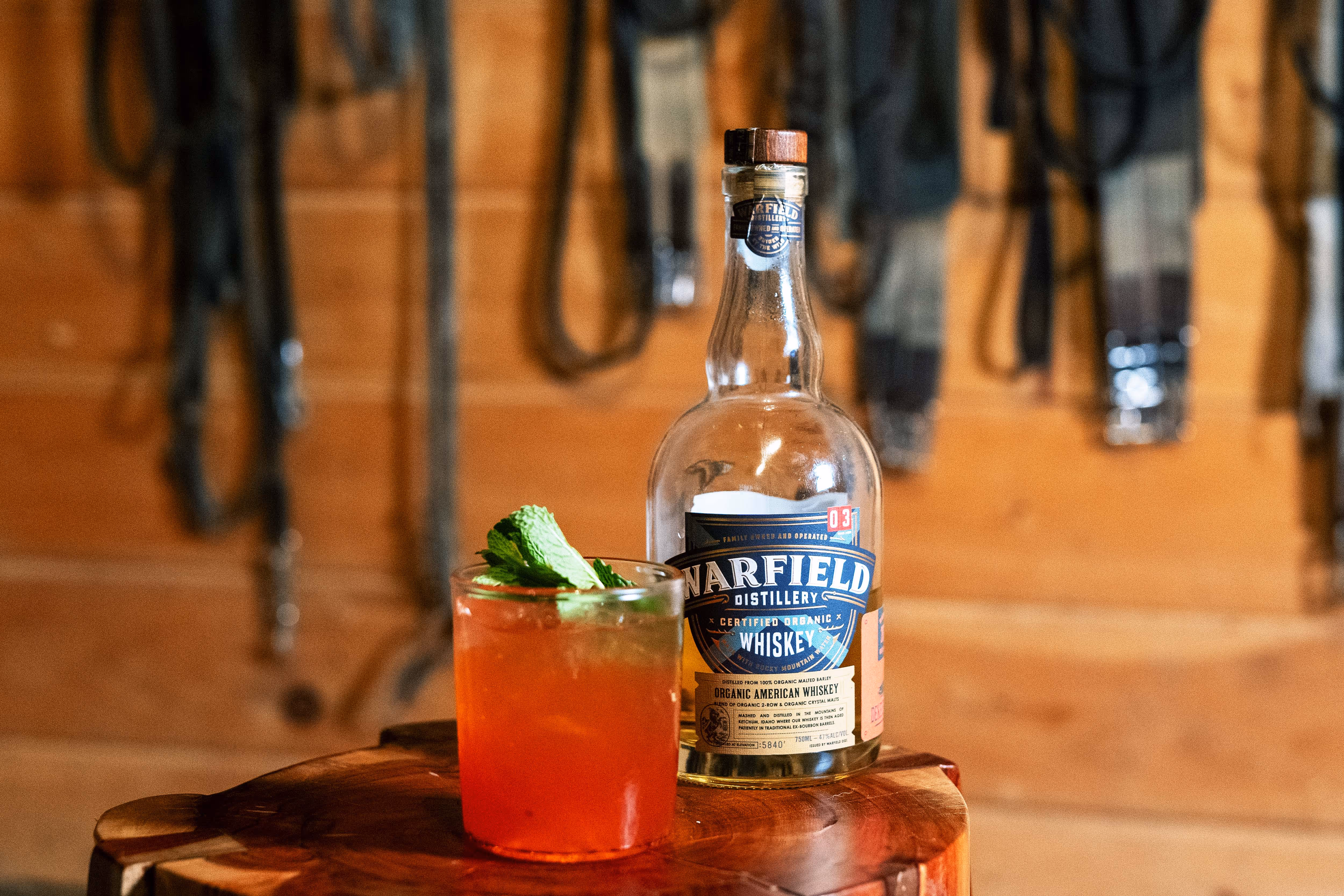 Whiskey bottle next to cocktail drink