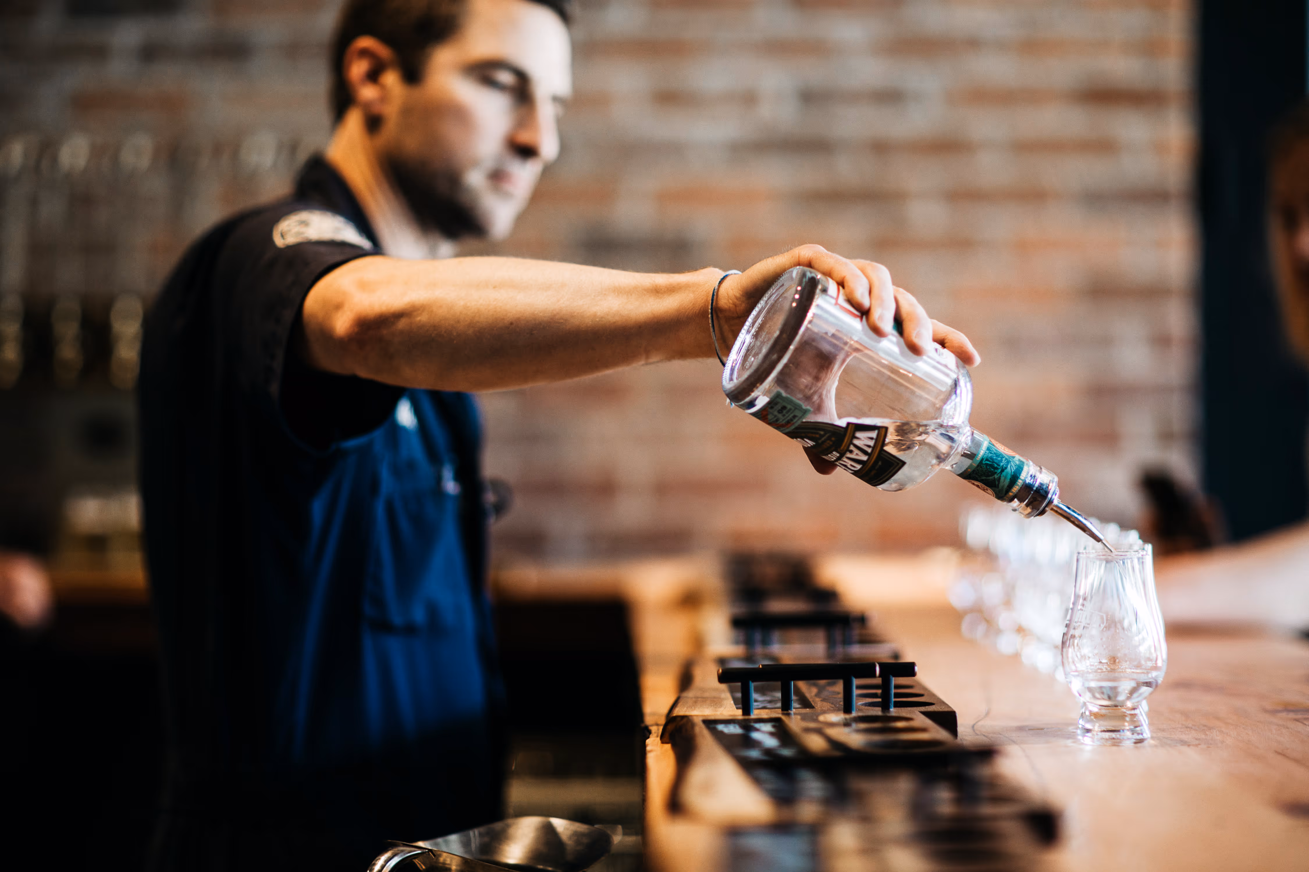 Man pouring vodka into glasses