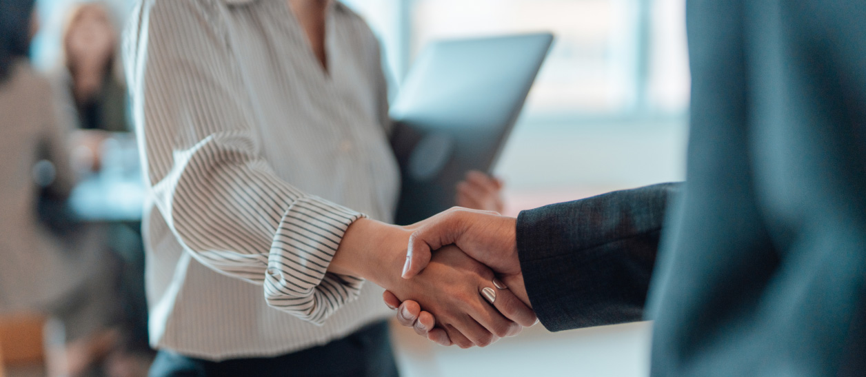 2 employees shaking hands in the office