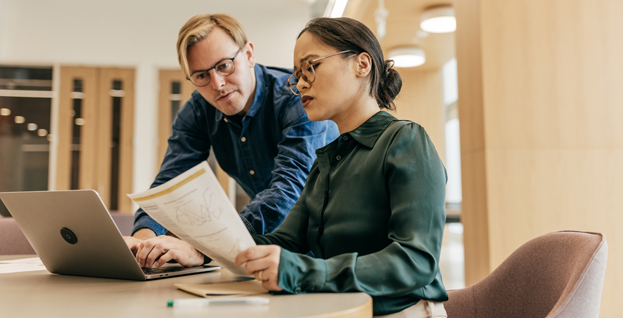 2 employees in a taxing and invoice action in front of a computer