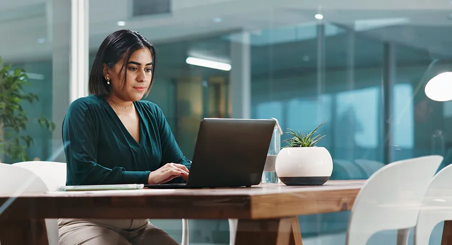 Woman working confidently on a laptop.