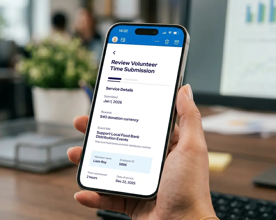 Hand holding a smartphone displaying a volunteer time submission review screen for supporting local food bank distribution events with details including $40 donation reward, volunteer name Liam Roy, employee ID 5896, 2 hours volunteered, and service date Dec 22, 2025.