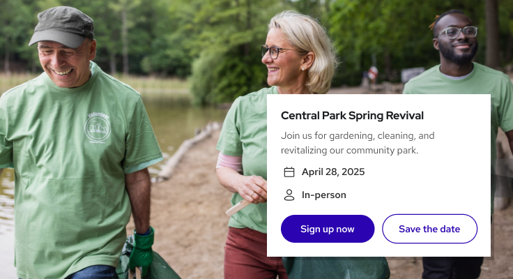 Three volunteers in green shirts walking outdoors near a pond, smiling and carrying gardening tools.