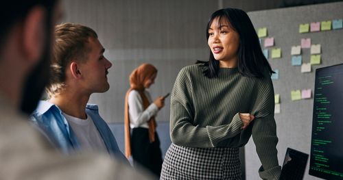 Employees team debating. A wall with sticker notes on the back