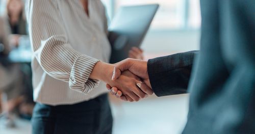 Two employees shaking hands in agreement, representing trust