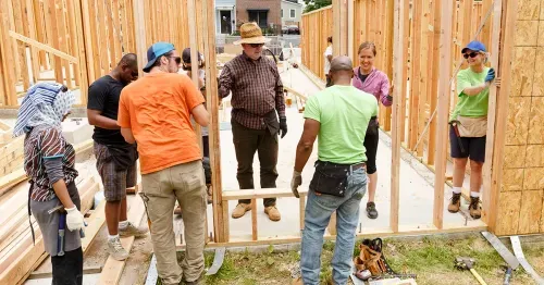 Group of volunteers helping build a house.