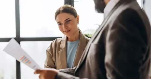 Image of a man and a woman in an office reviewing data.