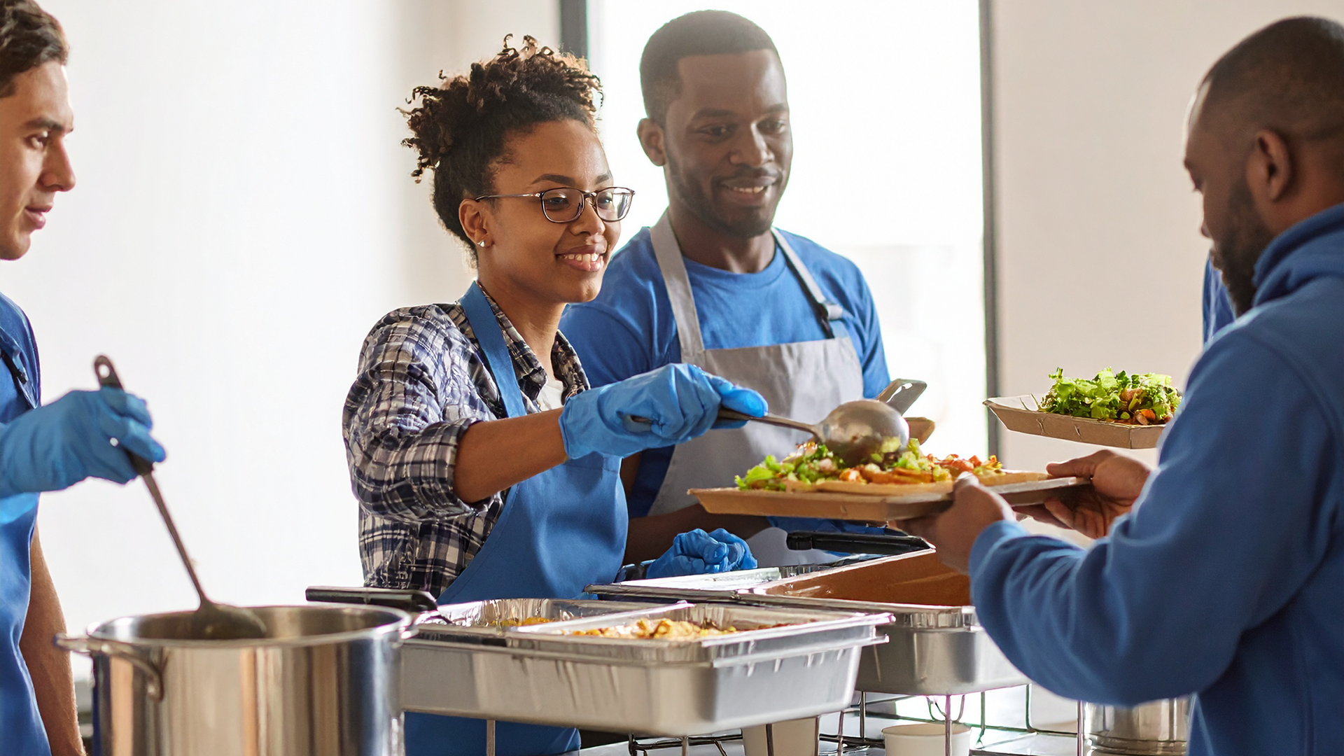 Volunteers serving meals to the underprivileged 