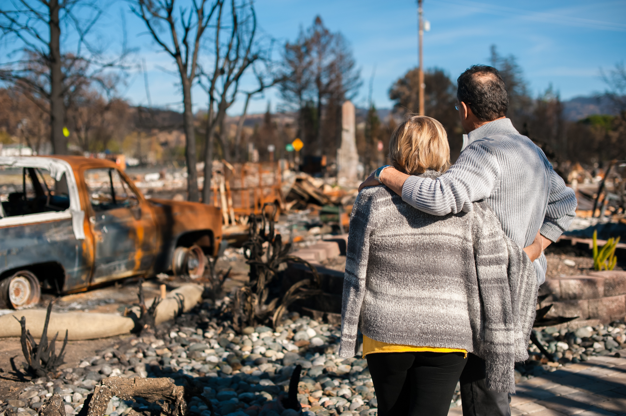 Man and woman looking at the aftermath of a natural disaster