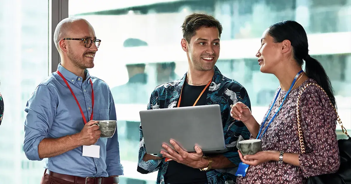 three colleagues talking together by a window