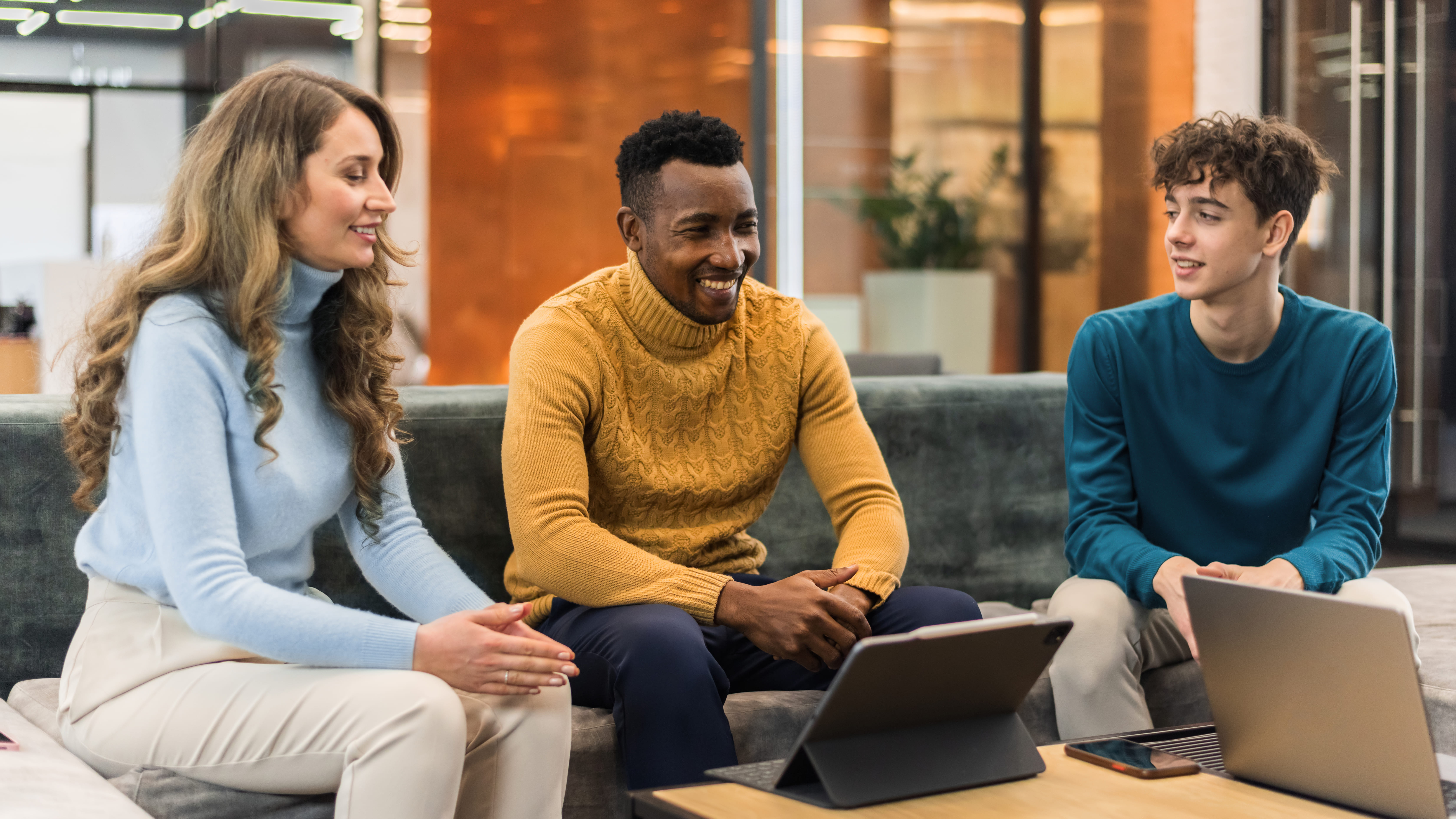 Group of two men and one woman discussing business in an office