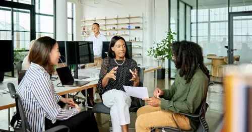 Three colleagues seated in an office, discussing strategy