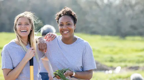Two people in gray shirts doing gardening volunteer work.