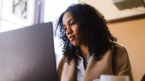 A woman looking at a laptop screen.