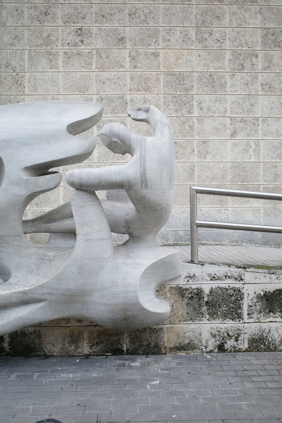 Abstract stone sculpture with organic shapes and human-like figures.