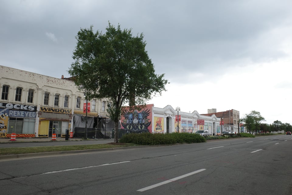 Street view of Detroit’s Eastern Market, with colorful murals and historic buildings under a cloudy sky.