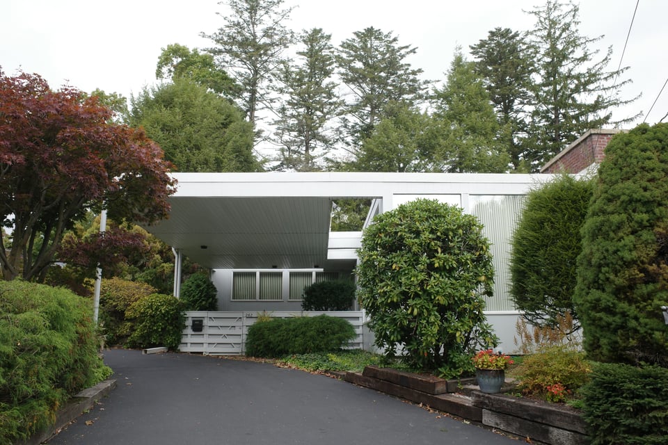 A low, white mid-century modern house.