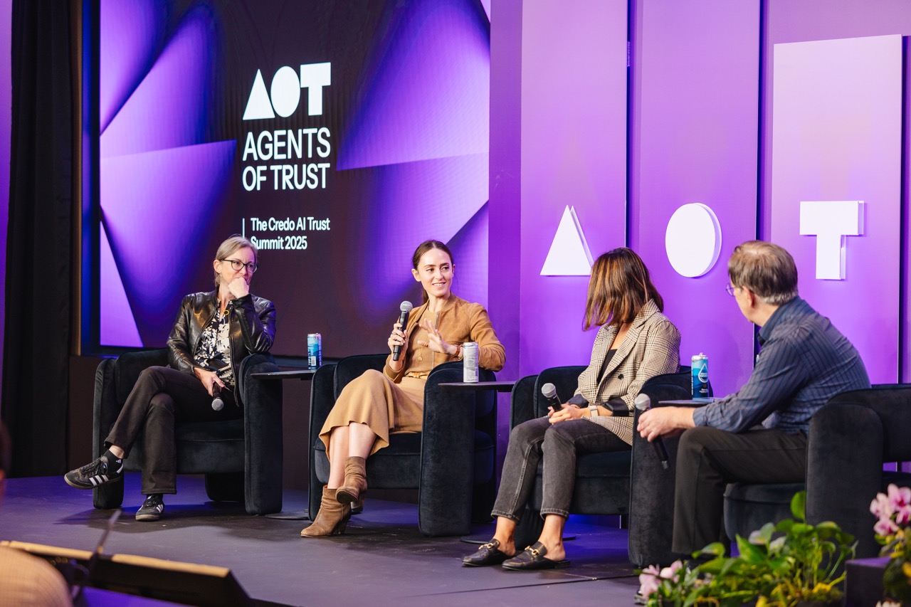 Four panelists sit on stage in armchairs discussing at the Agents of Trust Credo AI Trust Summit 2025 with a purple backdrop.