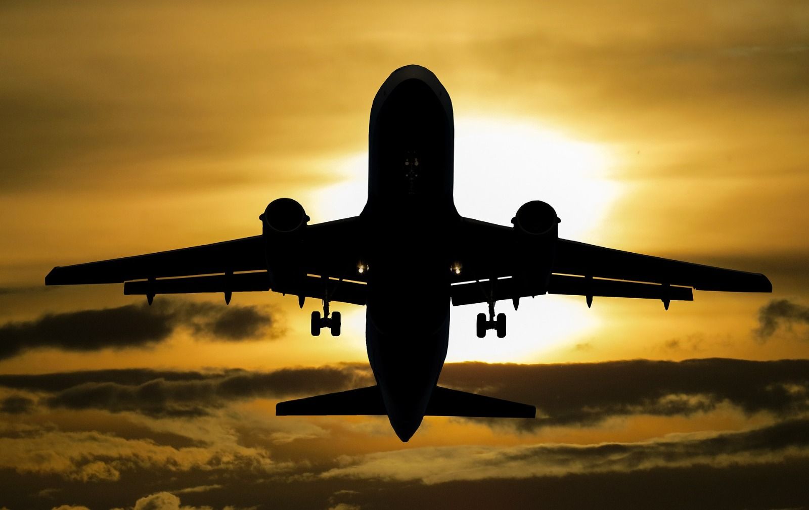 Plane flying through a sunset