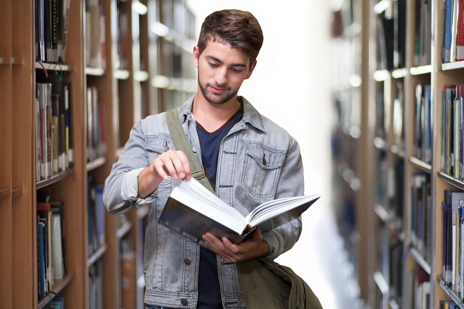 Student in a library looking at a book