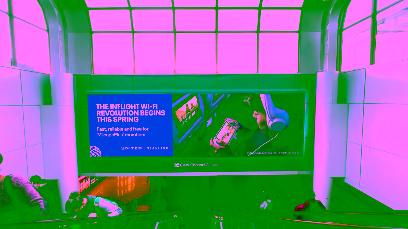 Sign above airport escalators advertising United Airlines aircraft with Starlink WiFi high-speed internet connectivity