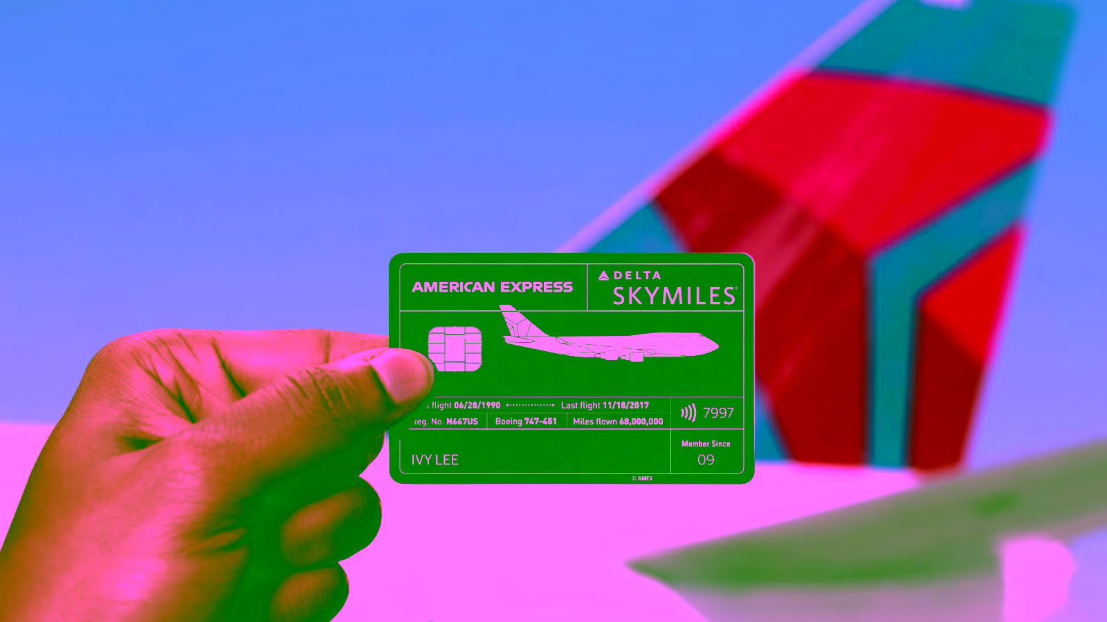 a delta skymiles credit card held up in front of a delta airlines airplane