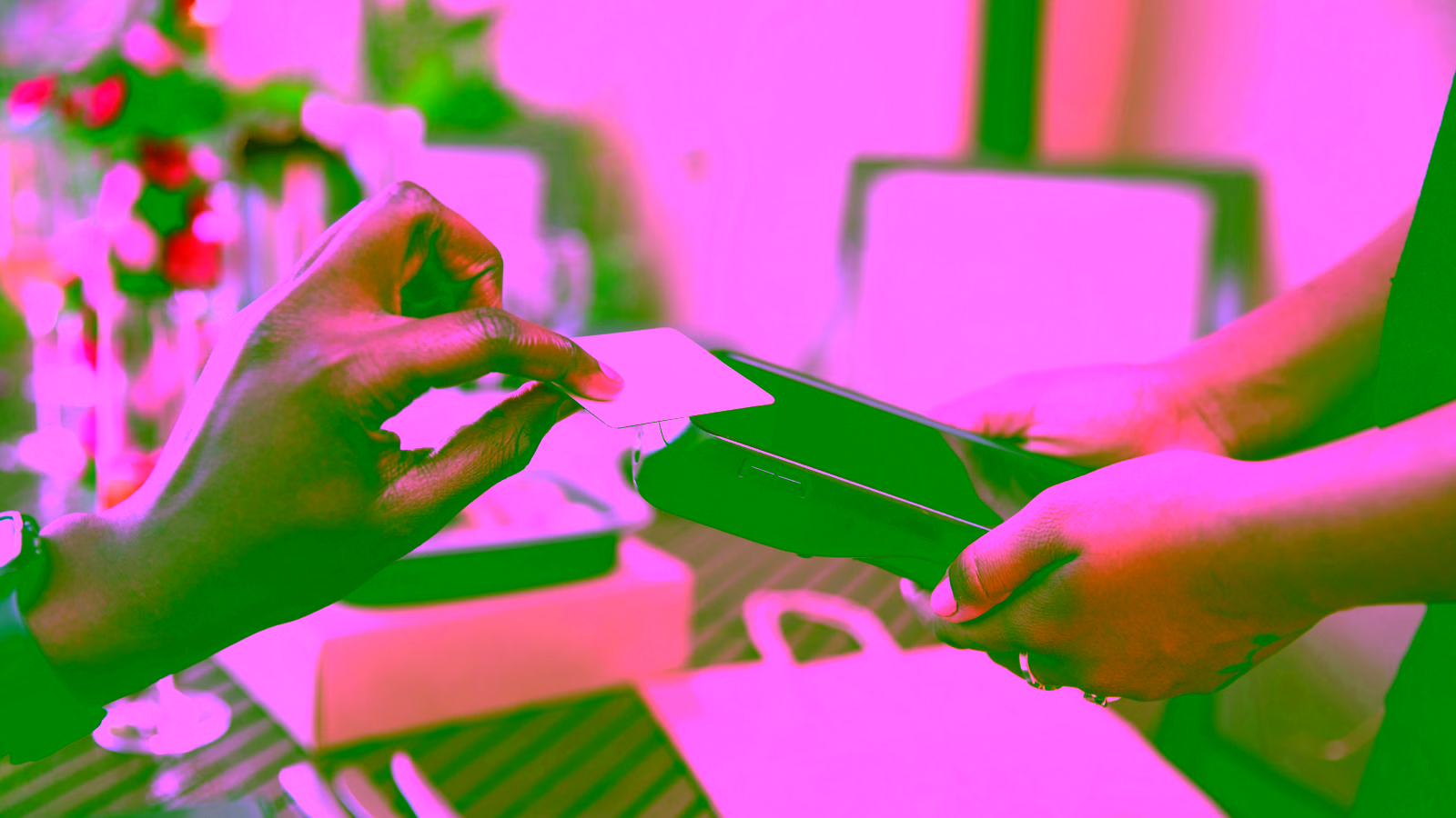 woman tapping her credit card to pay at a store