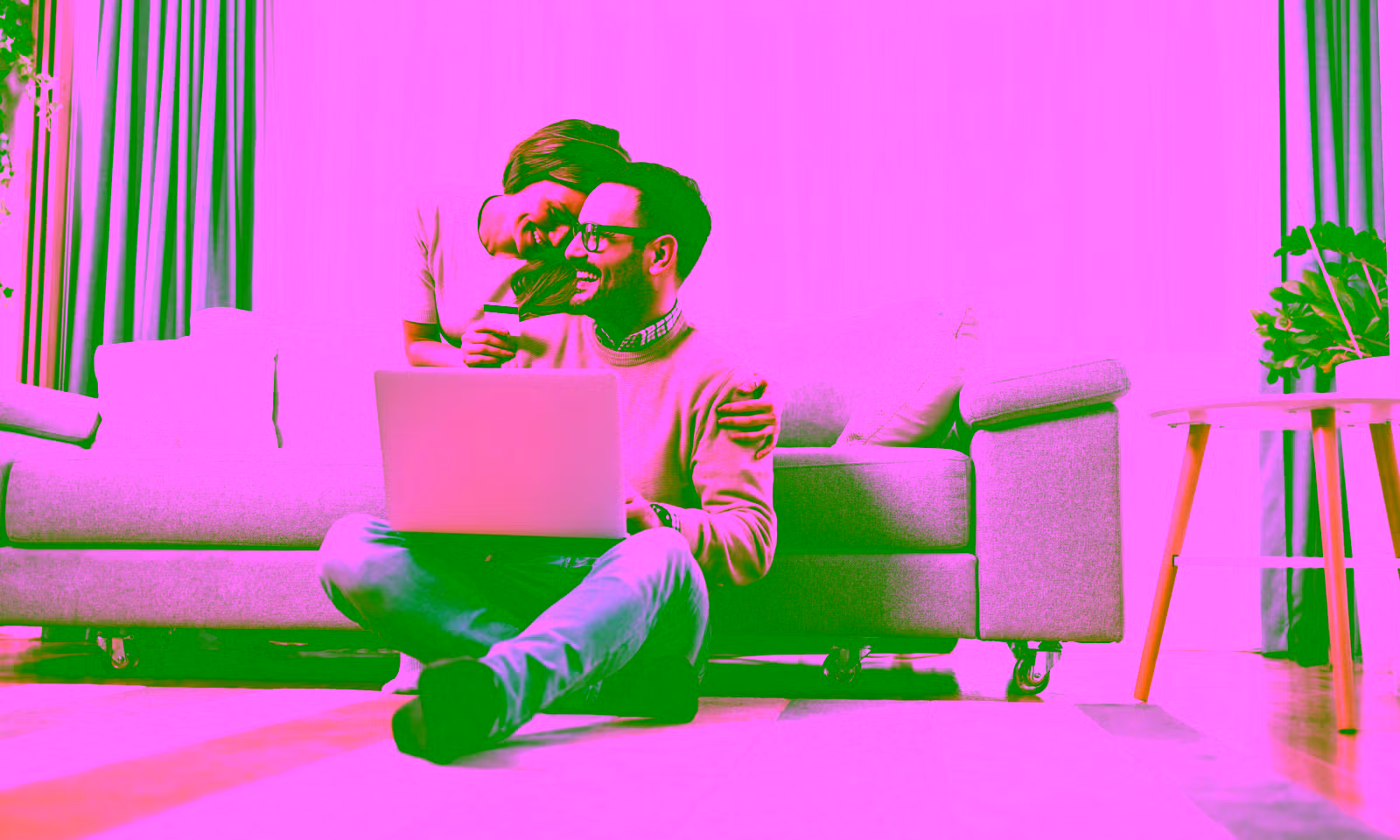 couple smiling with a computer and a credit card
