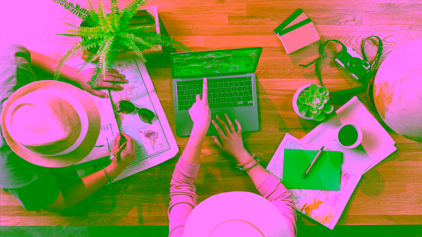 Travelers planning trip with maps and laptop