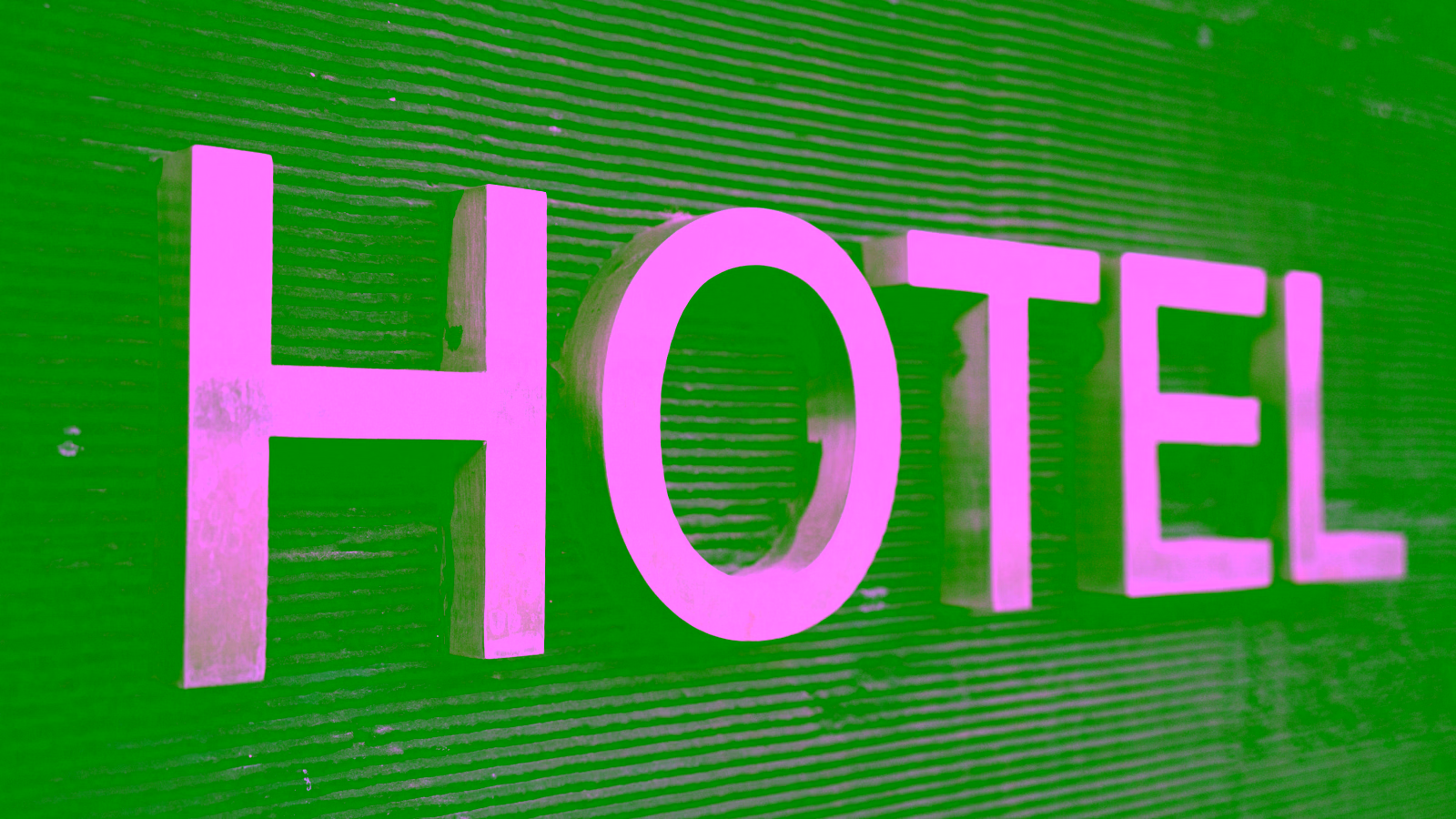 Metal hotel sign on dark wall